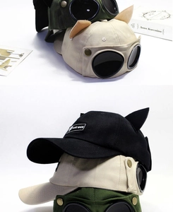 Detail showing pilot baseball cap with goggles, cat ears, and handmade label