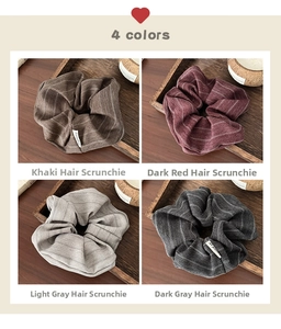 Set of four striped fabric scrunchies in khaki, red, and grey on a wooden tray