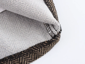 Vue macro de la texture à chevrons et de la doublure en mesh sur ce blazer court