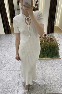 Dettaglio vestito midi in maglia bianca con texture a costine e scollo con lacci sottili