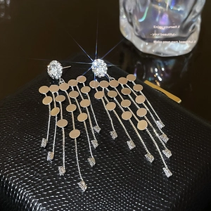 Macro shot of silver tassel earrings with round sequins and sparkling crystal detail