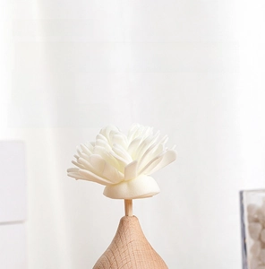 Minimalist car diffuser featuring a white flower on a semicircular wooden base