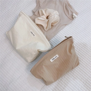 Macro view of textured cotton pouches with simple wish label and top zipper detail