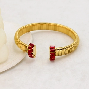Vista macro di un bracciale a cavo placcato oro con accenti in zircone rosso rubino