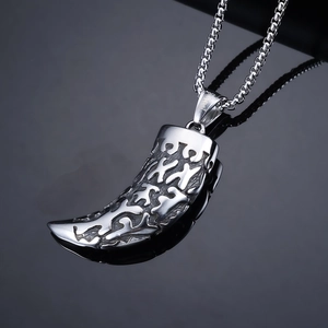 Vintage stainless steel wolf tooth pendant necklace with hollow pattern on dark background