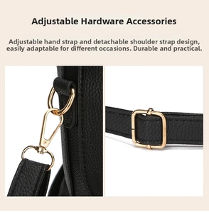 Detail of gold-tone spring hooks and adjustable buckle on black lychee leather bag