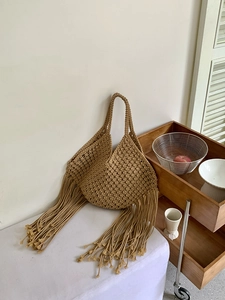 Dettaglio borsa a tracolla con frange in macramè fatta a mano, design di borsa mare in stile boho.