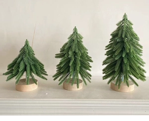 Detailed comparison of three green mini artificial Christmas trees with wooden bases