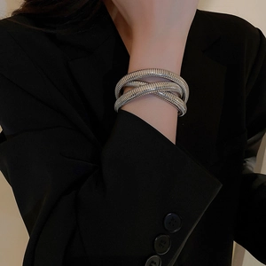 Macro shot of silver multi-layer spiral snake texture cuff on a model's wrist