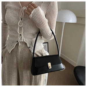Chic black PU leather baguette bag featuring a stylish gold-tone twist-lock closure detail