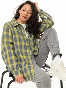 Detail of yellow and grey plaid flannel shirt featuring a casual loose fit and soft texture
