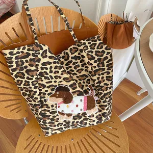 Detail of leopard print canvas tote bag featuring dachshund embroidery and dual-sided design