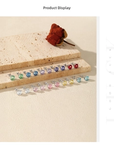 Detail view of colorful S925 sterling silver stud earrings arranged on a stone surface
