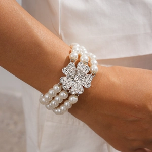Macro detail of multilayer pearl bracelet with a sparkling crystal clover centerpiece