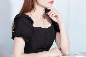 Golden key pendant necklace with shell inlay on female model with black square neck top