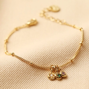 Gold bead chain bracelet with three round charms featuring pearl and colorful gemstones