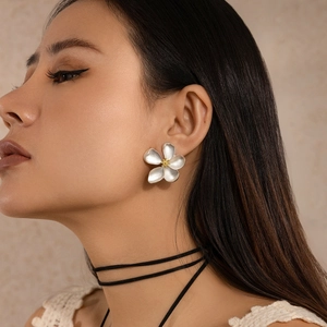 Elegant silver leaf flower earrings with gold pistils shown on a female model