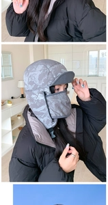 Close-up of grey textured winter bomber hat with integrated windproof mask and ear flaps