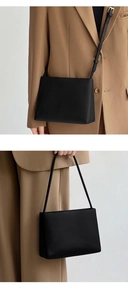 Detail view of the black PU leather square handbag worn as a shoulder and crossbody bag