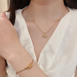 Schmuckset aus 18k vergoldeter Schaukelpferd-Halskette und schwarzem Perlenarmband