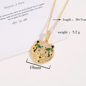 Close-up of 18K gold plated leopard pendant necklace with pavé zircon and green gem eyes