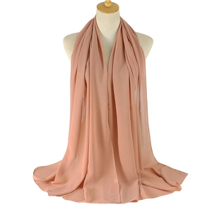 Detail of soft peach chiffon hijab draped on a mannequin with premium flowing texture