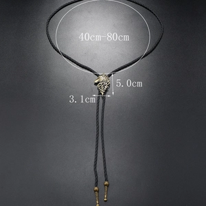 Detailed view of bronze wolf head Bolo Tie pendant and braided black leather cord