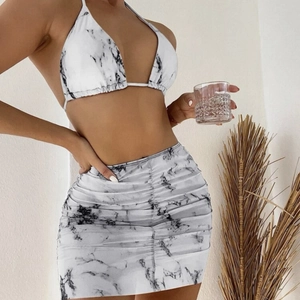 Three-piece marble print bikini set with ruched mesh skirt and halter top style