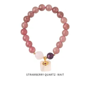 Close-up of strawberry quartz beads with evil eye charm and amethyst on stylish bracelet