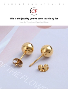Detailed close-up of gold ball stud earrings with classic butterfly backings