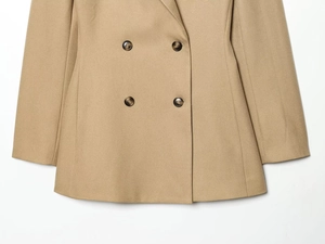 Detail of camel double-breasted blazer showing textured fabric and tortoiseshell buttons