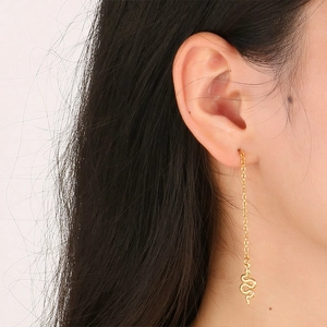 Close-up of golden snake pendant drop earrings on model showcasing textured metal detail
