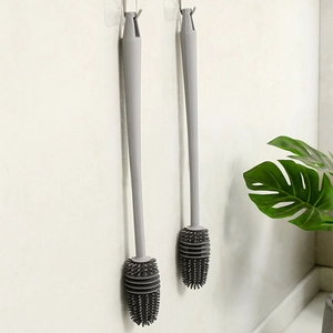 Long-handled gray silicone bottle cleaning brush set hanging on a white tiled wall