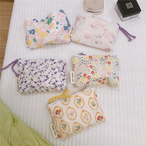 Detail of assorted floral cotton mini pouches with simple wish tags and colorful zippers