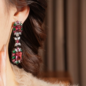 Close-up of vintage style dangle earrings with colorful zircon stones on female model