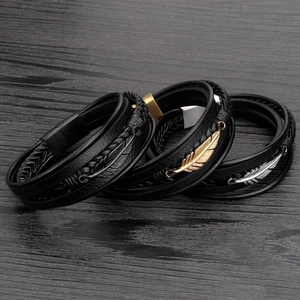 Detailed view of layered leather bracelets with black, gold, and silver feather charms