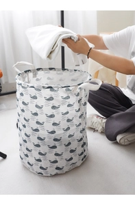 Close-up of laundry basket with whale pattern and handles in bright room