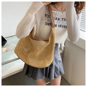 Detail of beige woven hobo bag with contrast brown leather strap and mesh texture