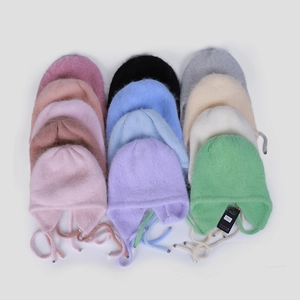 Detailaufnahme flauschiger Angora-Wintermützen in verschiedenen Morandi-Farben
