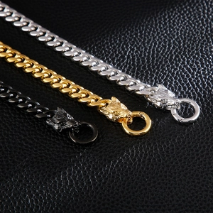Detailed view of three-color wolf head lobster clasps on thick Cuban link chains