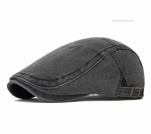 Close-up of black retro flat cap with adjustable side metal buckle and visible stitching