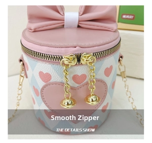 Detailed view of the golden zipper and cute pink heart pattern on this girls bucket bag