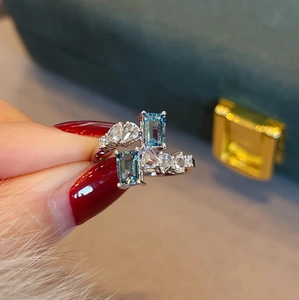 Luxuriöser offener Ring mit meeresblauen Kristallen und asymmetrischem Silberdesign