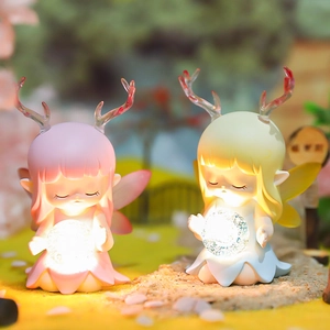 Close-up of cute deer fairy figurines with glowing crystal balls on miniature grass