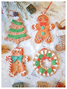 Close-up of gingerbread man and Christmas tree ornaments with frosted texture details