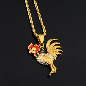 Golden rooster pendant necklace with crystals and red enamel on a black reflective surface