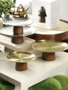 Detail of high and low cake stands with gold or silver metal tops and wood bases