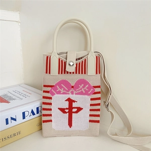 Detail of knitted tote bag with red gift pattern and magnetic buckle closure