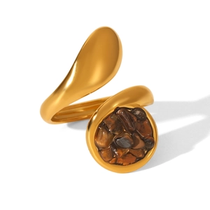 Detail of round gold-plated ring featuring brown natural stone inlay on a white background