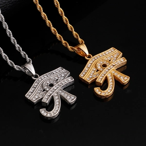 Macro detail of gold and silver Eye of Horus necklaces with rhinestones on black background